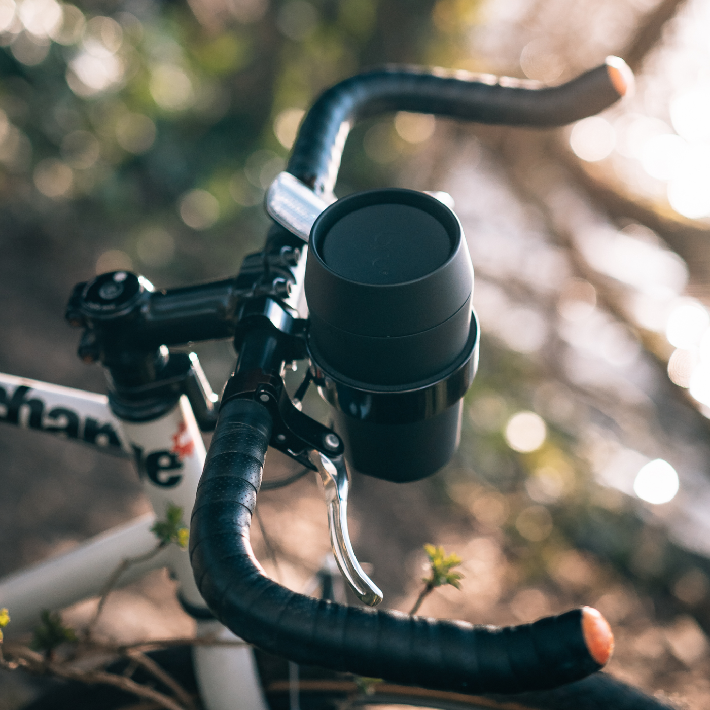 bru black insulated travel mug mounted in a holder on a road bike handlebar
